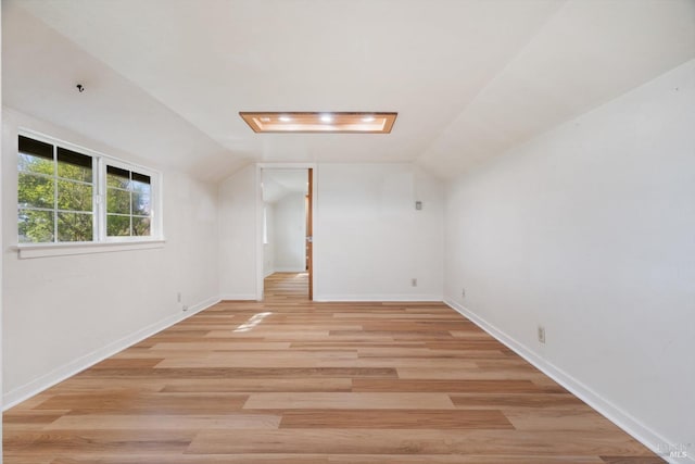 bonus room with lofted ceiling, baseboards, and light wood-style flooring