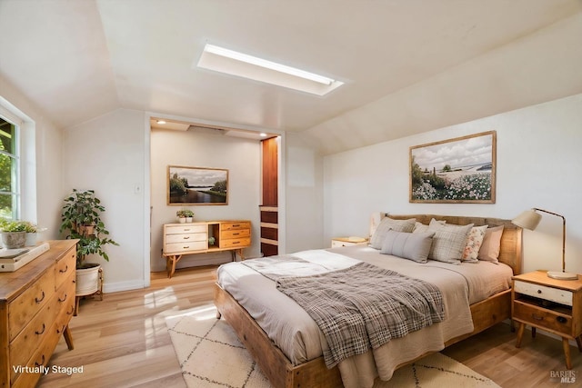 bedroom featuring lofted ceiling, baseboards, and light wood-style flooring
