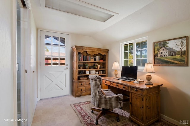 office with light floors and vaulted ceiling