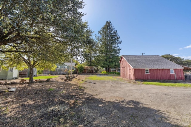 view of yard with an outbuilding and fence