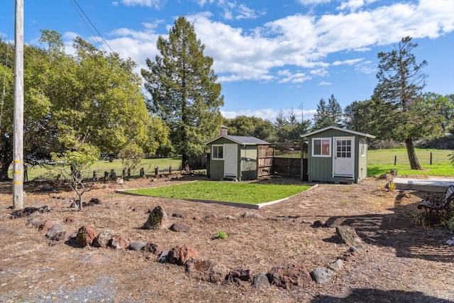 view of yard featuring fence, an outbuilding, and a storage shed