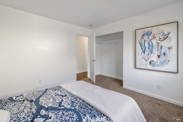 carpeted bedroom featuring a closet and baseboards