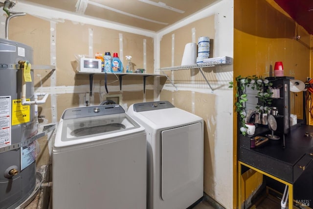 clothes washing area with independent washer and dryer, water heater, and laundry area