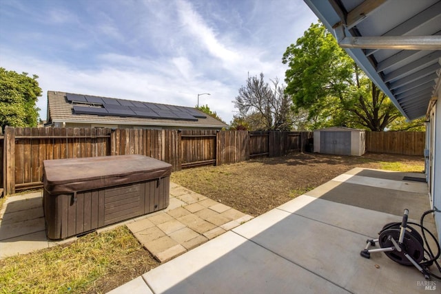 view of patio / terrace featuring a shed, an outbuilding, a fenced backyard, and a hot tub