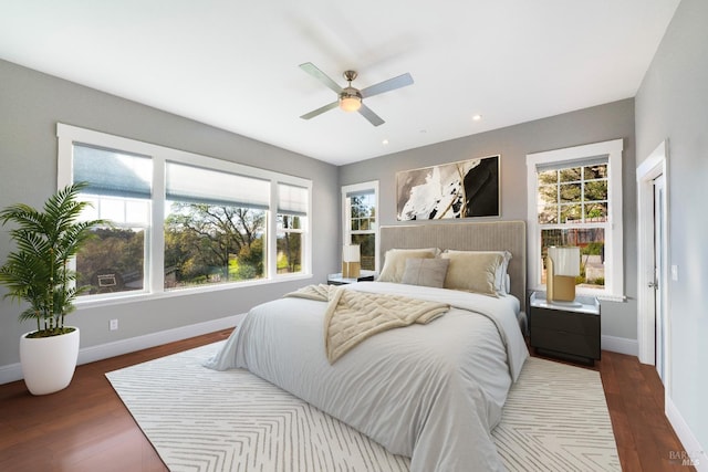 bedroom featuring baseboards, multiple windows, recessed lighting, and wood finished floors