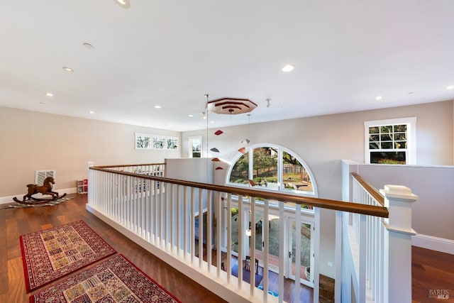hallway with recessed lighting, baseboards, an upstairs landing, wood finished floors, and visible vents