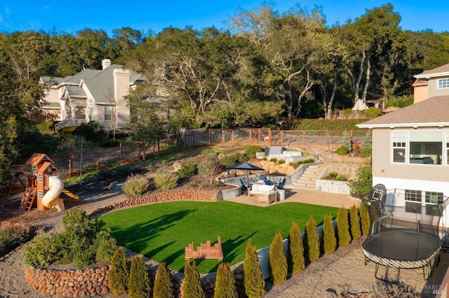 view of yard featuring a playground, fence, and stairway