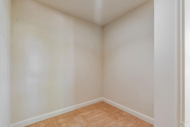 unfurnished room with light carpet and baseboards