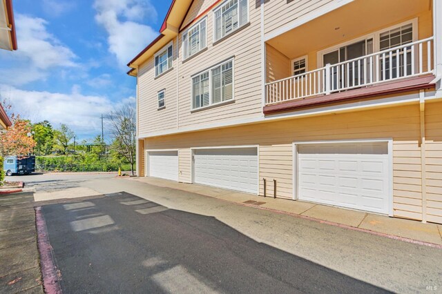 view of side of property with a garage and a balcony