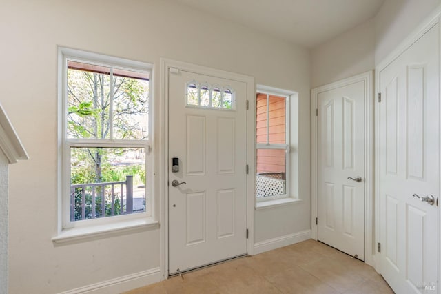 entryway with light tile patterned floors and baseboards