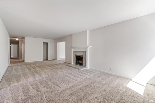 unfurnished living room with light colored carpet, baseboards, and a fireplace
