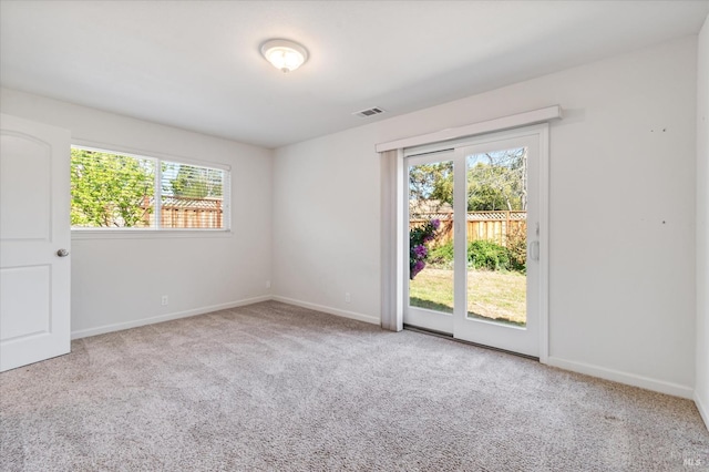 spare room with baseboards, carpet flooring, and visible vents