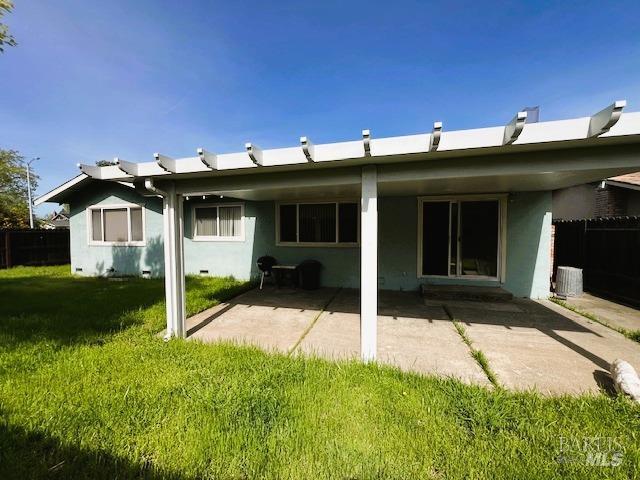 back of property with a patio, stucco siding, and a lawn
