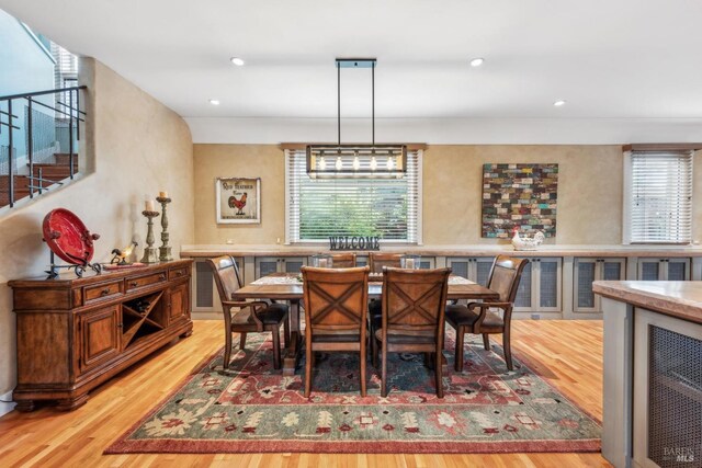 dining area featuring stairs, a wealth of natural light, recessed lighting, and wood finished floors
