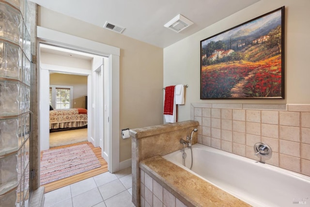 ensuite bathroom with tile patterned flooring, connected bathroom, visible vents, and a bath