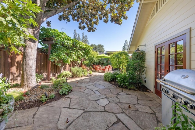 view of patio featuring area for grilling, french doors, and fence