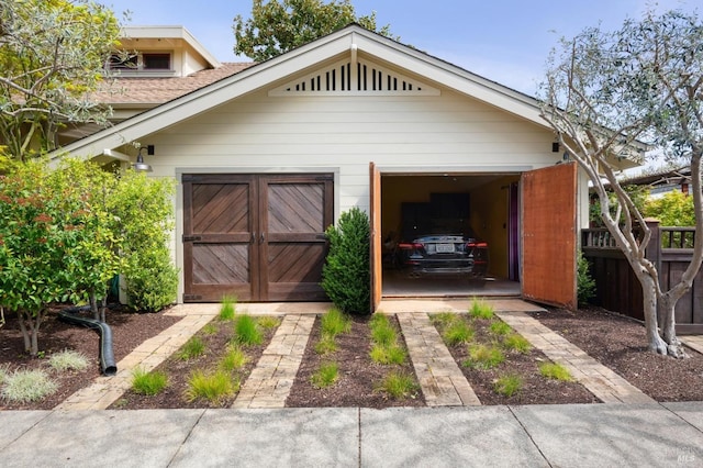 garage featuring dirt driveway and fence