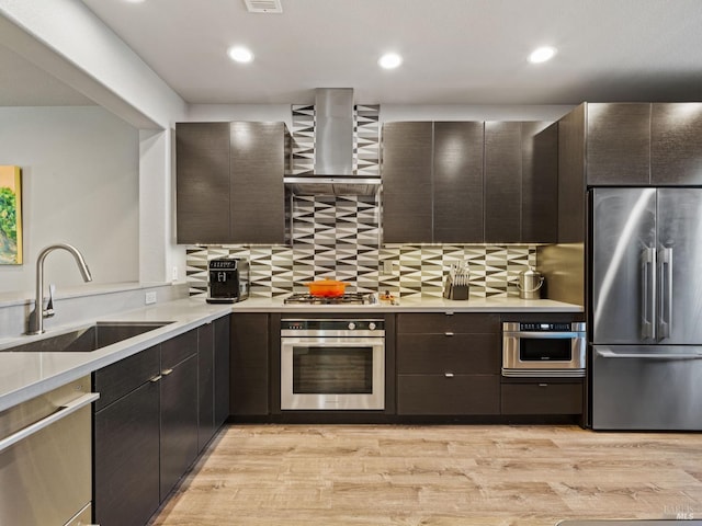 kitchen with tasteful backsplash, light wood-type flooring, stainless steel appliances, and a sink