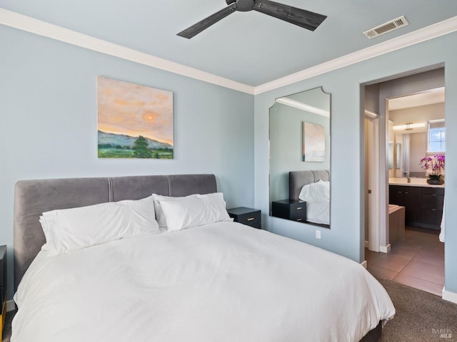 carpeted bedroom featuring connected bathroom, tile patterned floors, crown molding, a ceiling fan, and visible vents