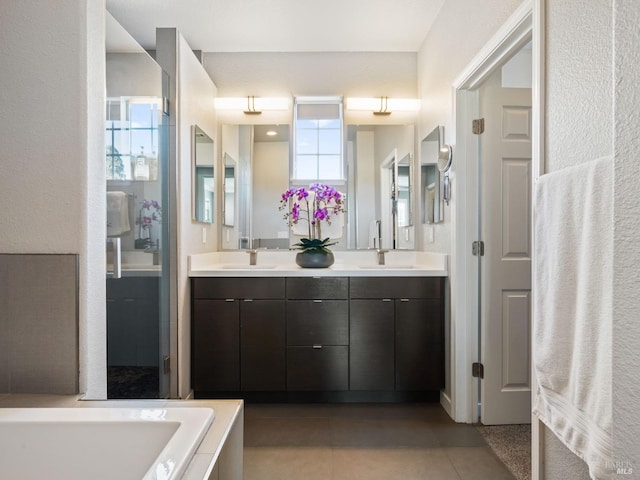 full bathroom with tile patterned floors, a tub, double vanity, and a sink