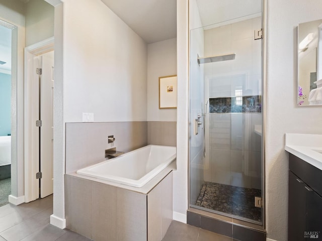 full bathroom featuring a shower stall, vanity, a bath, tile patterned floors, and ensuite bath