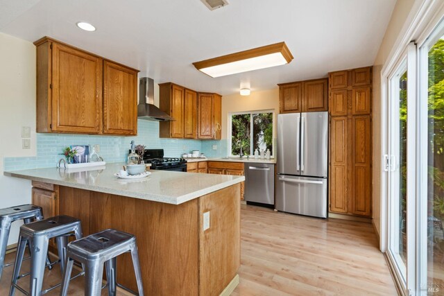 263 Carlisle Way, Benicia, CA 94510 - kitchen with appliances with stainless steel finishes, wall chimney exhaust hood, a peninsula, brown cabinets, and recessed lighting