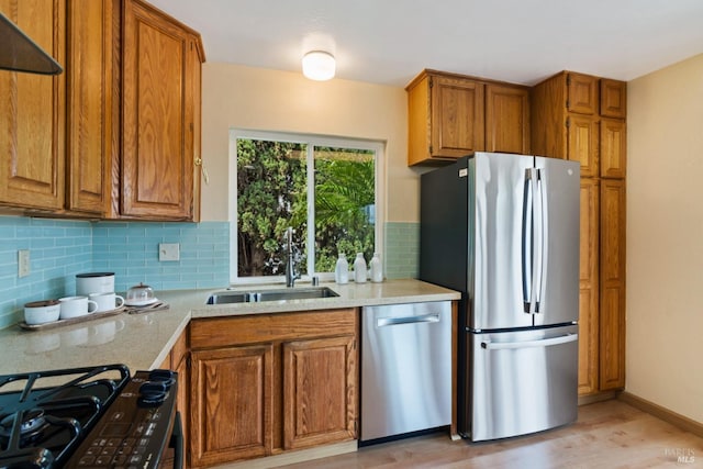 263 Carlisle Way, Benicia, CA 94510 - kitchen featuring appliances with stainless steel finishes, a sink, brown cabinetry, backsplash, and light wood finished floors