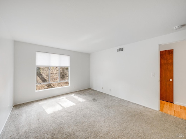 carpeted empty room with visible vents