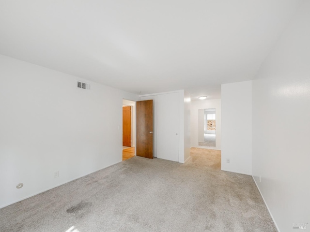spare room with visible vents and light carpet