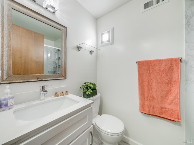 bathroom featuring visible vents, toilet, a shower stall, and vanity