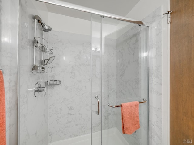 full bathroom with a marble finish shower