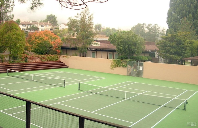 view of tennis court with fence and community basketball court