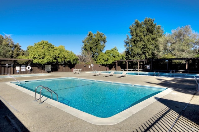 pool featuring a patio and fence