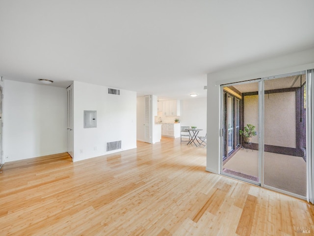 unfurnished room featuring plenty of natural light, visible vents, and light wood-type flooring