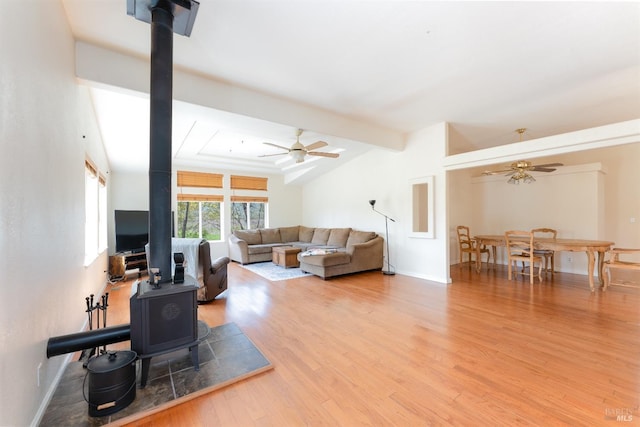 13679 Powerhouse Rd, Potter Valley, CA 95469 - living room featuring baseboards, lofted ceiling with beams, a wood stove, ceiling fan, and wood finished floors