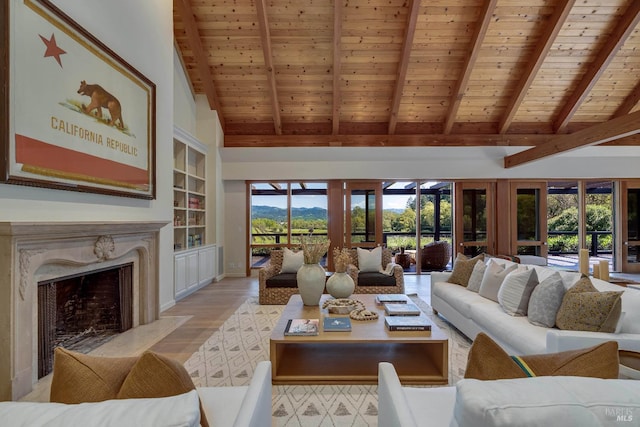 living area with beam ceiling, light wood-style flooring, a premium fireplace, and wood ceiling