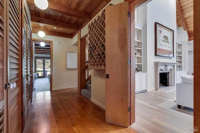 living area with beam ceiling, wood finished floors, and wood ceiling