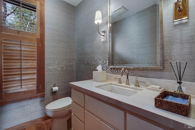 bathroom featuring vanity, visible vents, and toilet