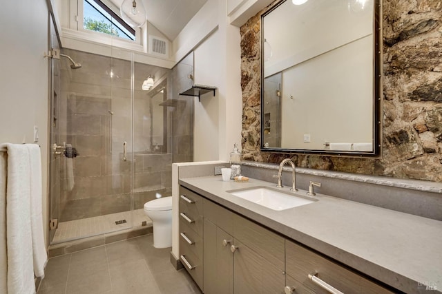 full bath with toilet, vanity, tile patterned floors, a stall shower, and lofted ceiling