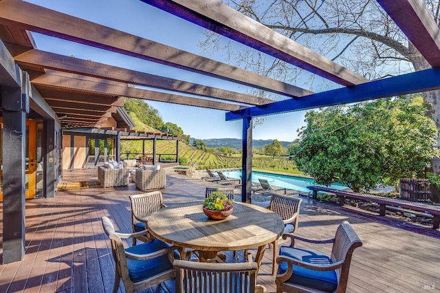wooden deck featuring an outdoor pool, a mountain view, outdoor dining area, and a pergola