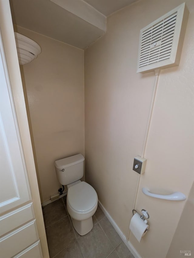 bathroom featuring toilet, visible vents, tile patterned floors, and baseboards