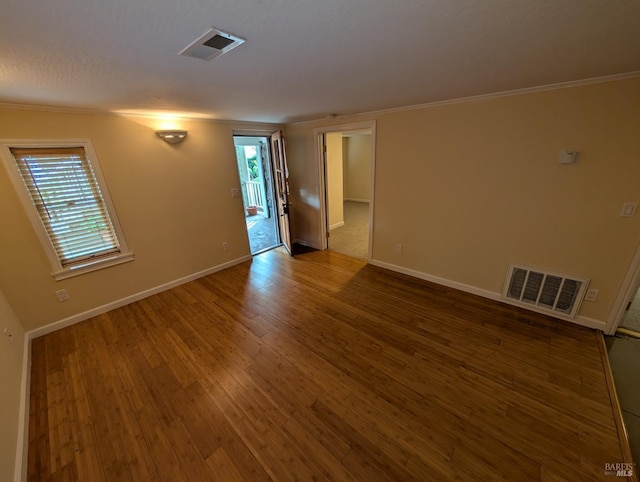empty room featuring visible vents, plenty of natural light, and wood finished floors