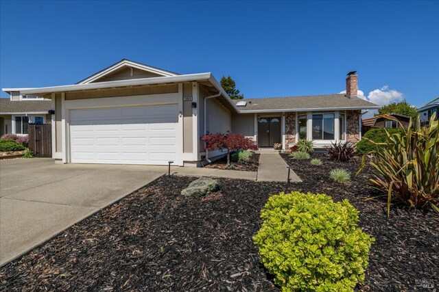 single story home featuring an attached garage, driveway, stone siding, and a chimney