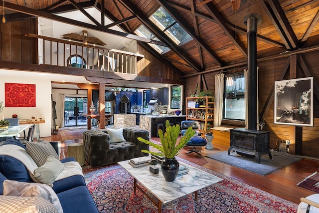 living area featuring a wood stove, wooden ceiling, high vaulted ceiling, wooden walls, and hardwood / wood-style floors