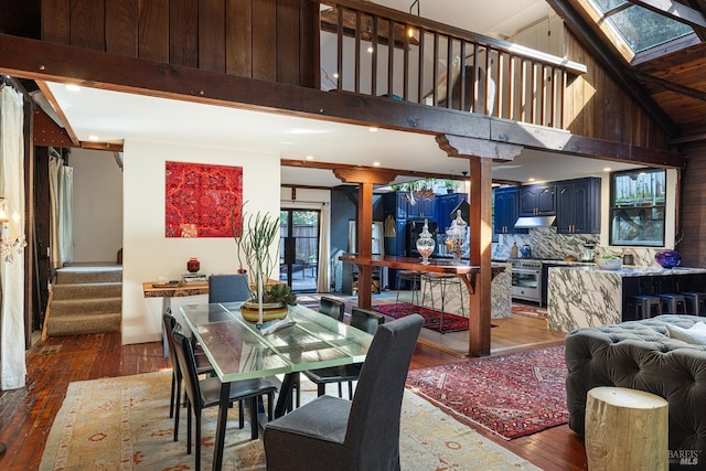 dining space with hardwood / wood-style floors, stairway, a high ceiling, and recessed lighting