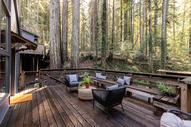 wooden deck with a wooded view and outdoor lounge area