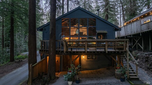 back of house with a deck, stairs, and driveway