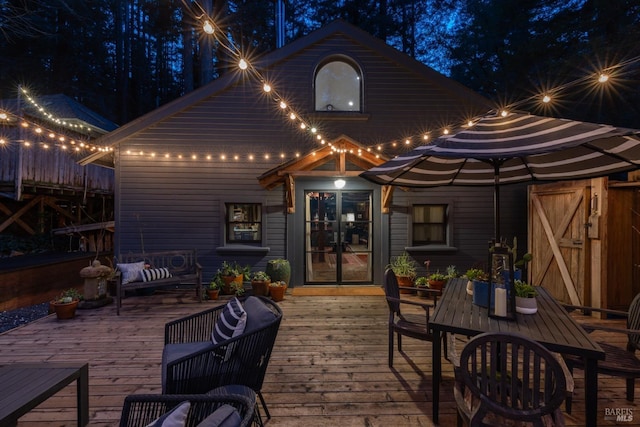 back of house at twilight featuring a deck