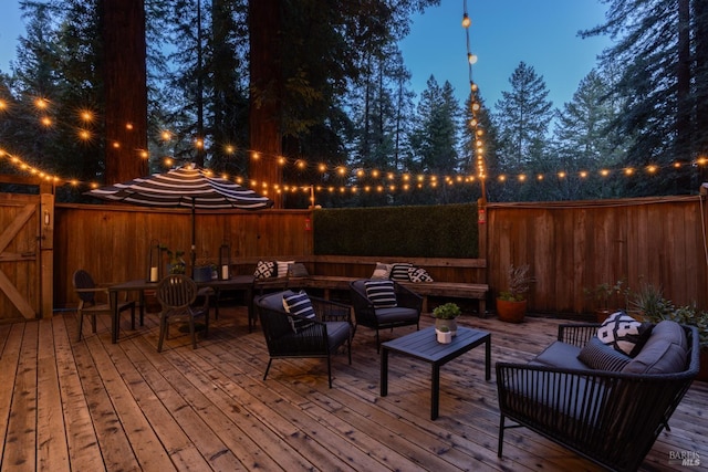 exterior space with an outdoor living space, a wooden deck, and a fenced backyard