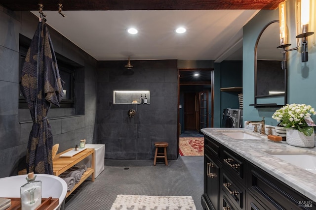 full bath featuring a sink, double vanity, recessed lighting, a walk in shower, and washer / dryer